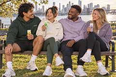Friends on a park bench with Matchi matcha latte cans