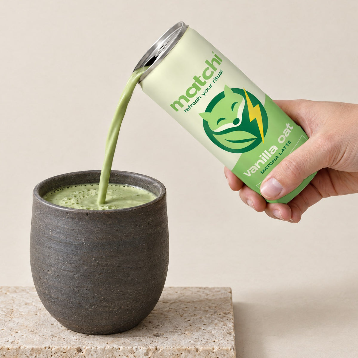 A hand pours Matchi Vanilla Oat canned matcha latte into a dark stoneware cup